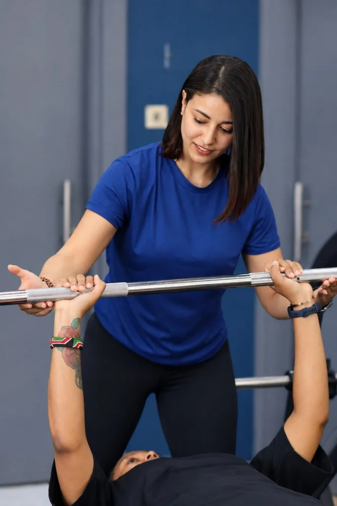 Personal trainer spotting a bench press for a client