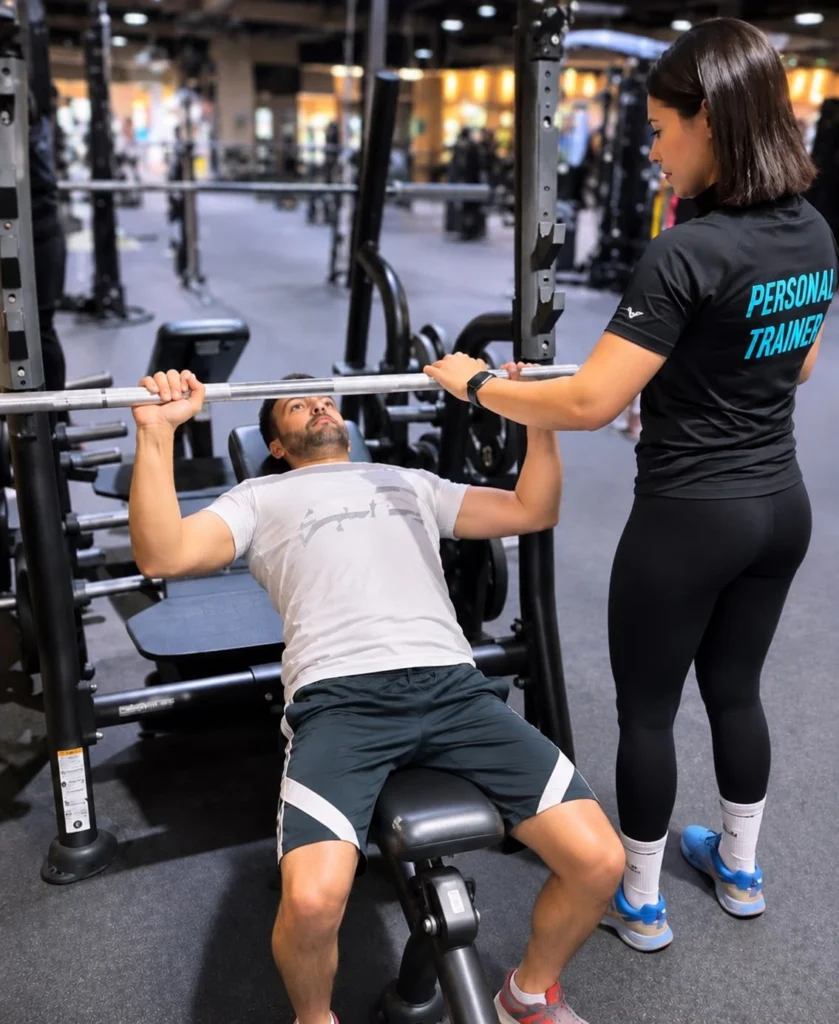 JazFit personal trainer spotting a client on the incline bench press